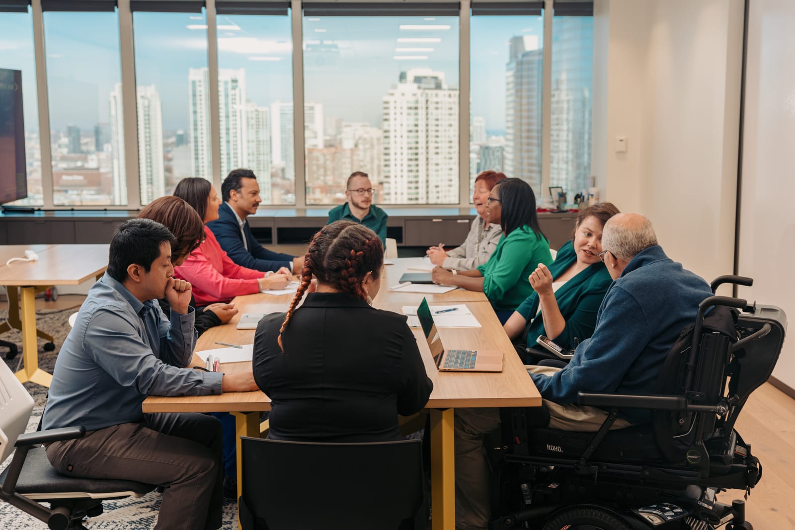 A diverse group of colleagues collaborating in an office, showing inclusive community support.